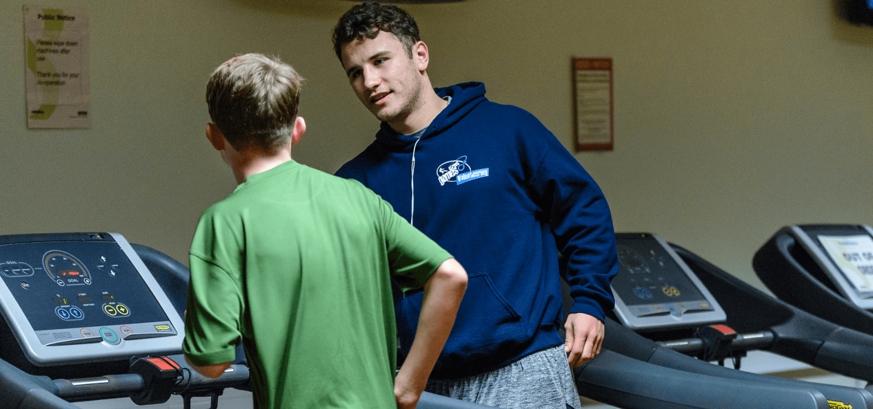 Volunteering gym trainer talking to jogger