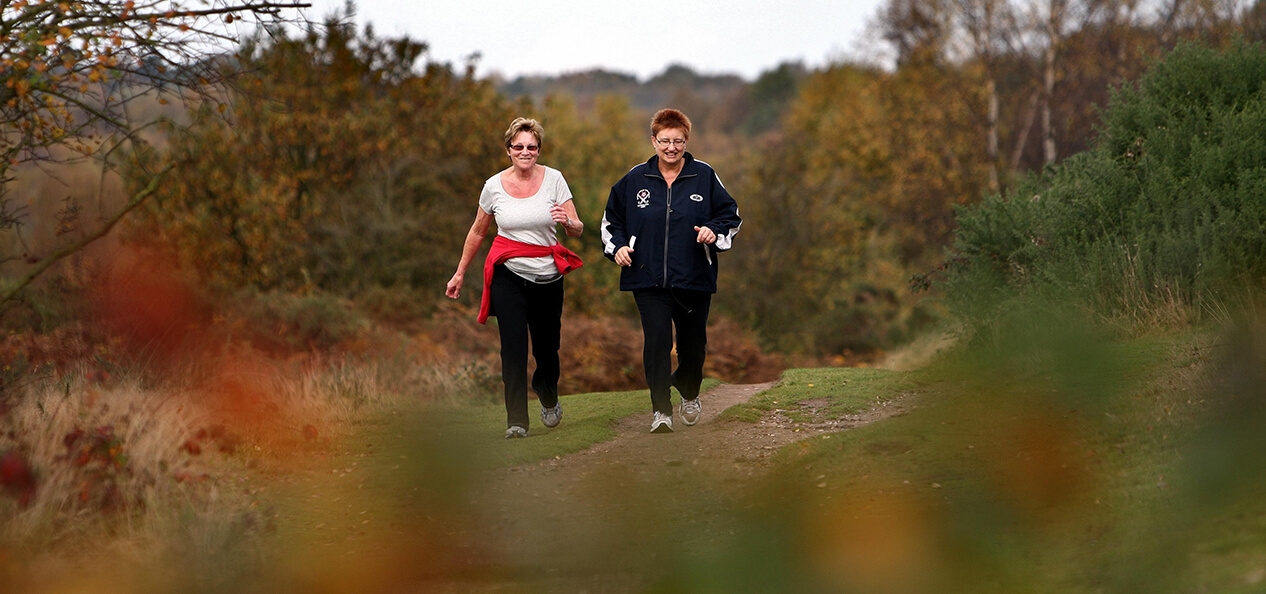 Two women walking together in a park