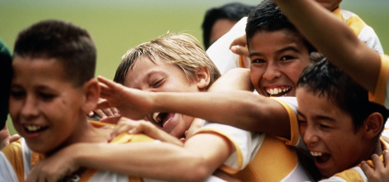 A group of young boys celebrate at a football match. Credit: Juan Silva/The Image Bank via Getty Images.