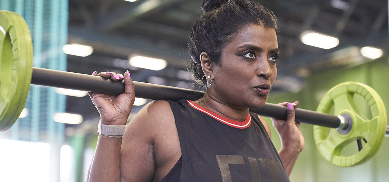 A woman lifts weights in a gym
