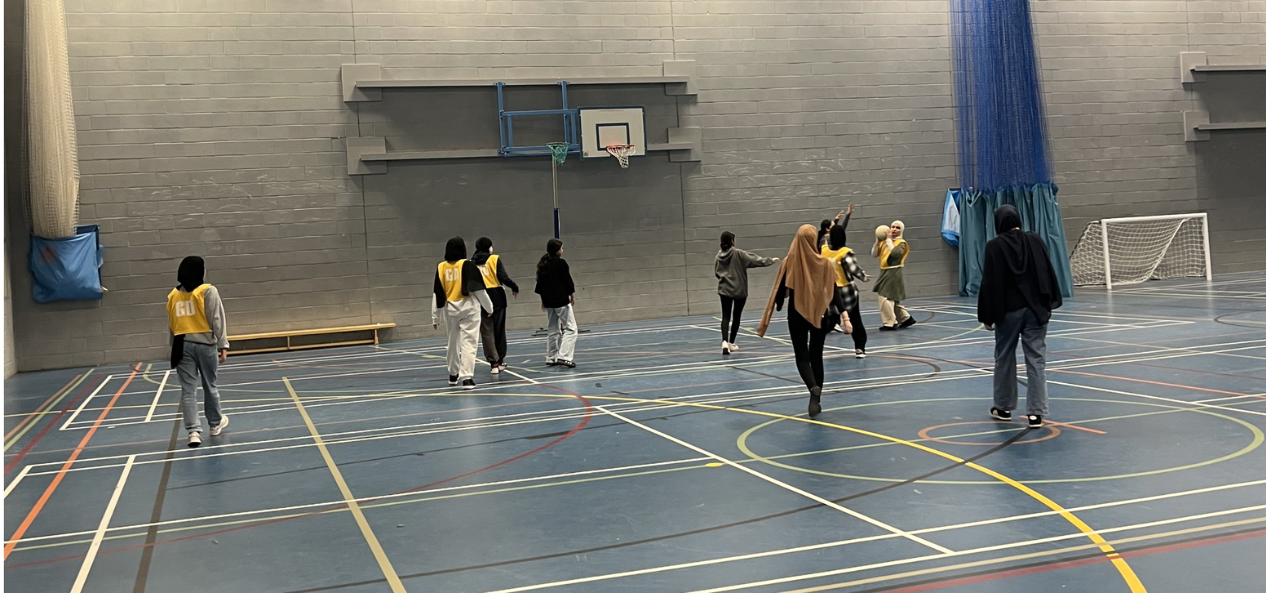Group of girls playing netball in sports hall