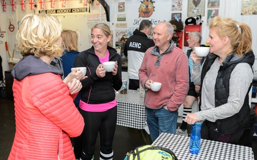 A group of people have a cup of team in a club house.