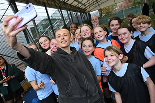England footballer Chloe Kelly takes a selfie with a groups of girls at an after-school football club