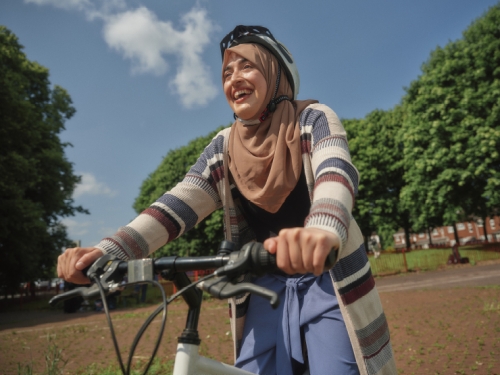 A woman rides a bike in the park