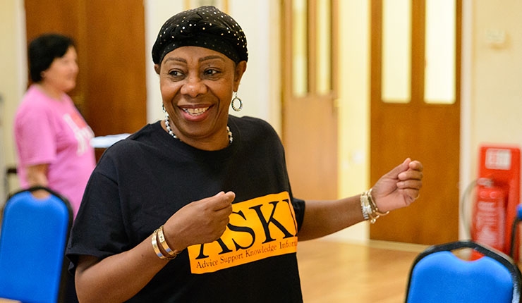 A woman smiling during a chair exercise session.