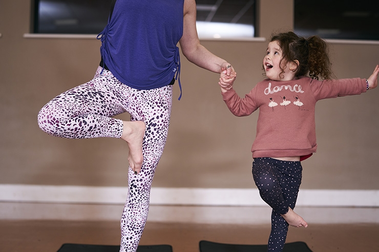 A woman and her daughter do yoga together