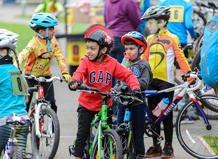 A group of children with their bikes at an outdoor activity centre.