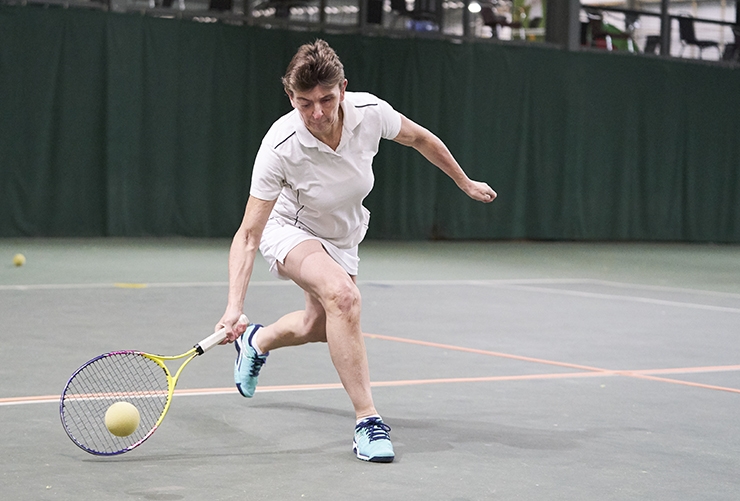 A visually impaired woman plays tennis.
