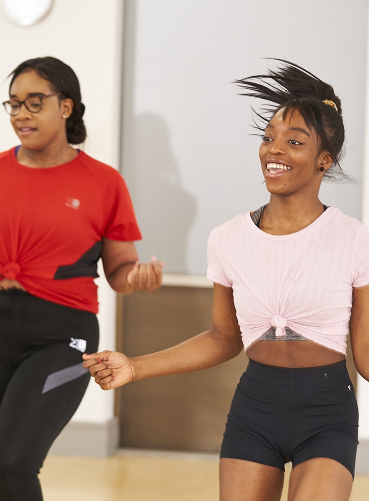 A woman smiles in an exercise class