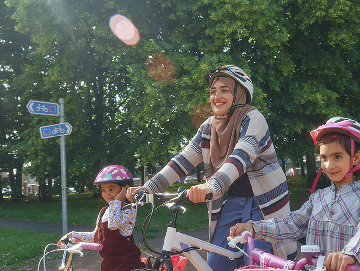 A mum rides her bike with her two daughters