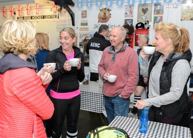 A group of people have a cup of tea in a club house.