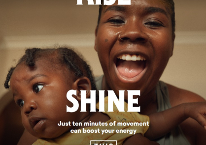 A woman smiles at the camera while holding her baby, with the words 'rise and shine' in large font on the image