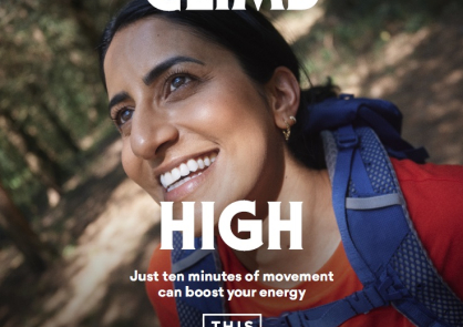 A woman looks up at the trees as she walks in woodland, with the words climb high on the image in large font