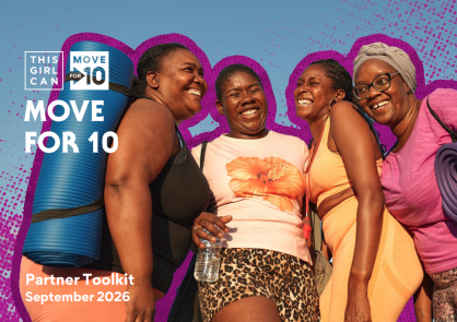 Four black women smile and laugh in a group as two of them have yoga mats thrown over their shoulder